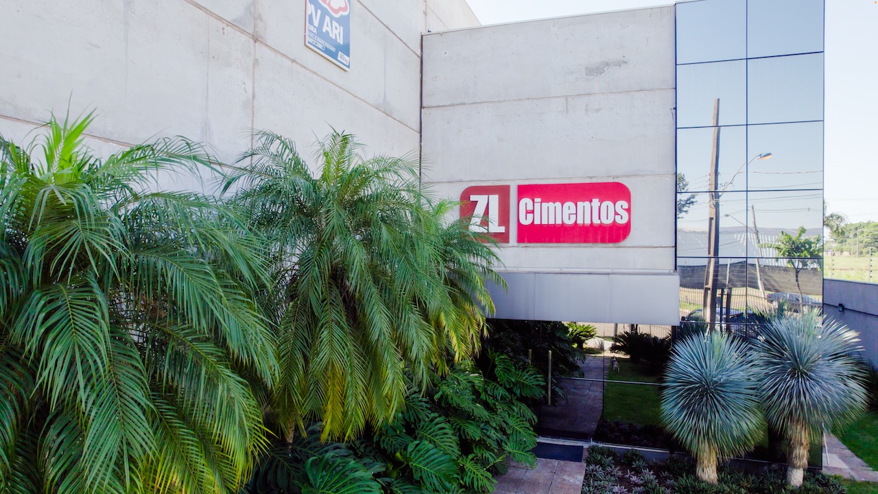 Fachada da sede com o logo ZL Cimentos e jardim